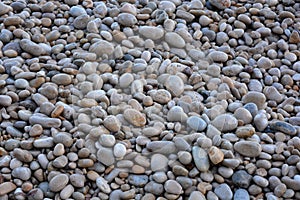 Wet, grey,  pebbles on a beach