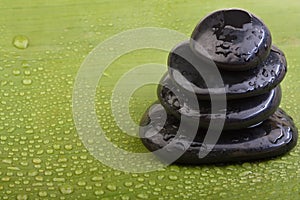 Wet hotstones on green banana leaf