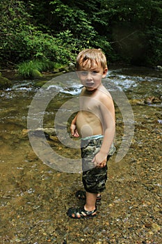 Wet little blond boy playing in the creek waterCherokee Tennesee