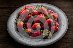 Wet metal plate full of fresh, ripe red, wet strawberries