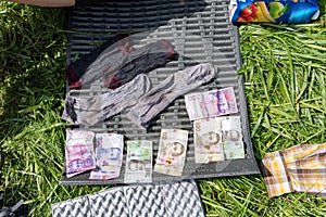 Wet money on the carpet. Washed money is dried in the sun. Wet things and money are dried.