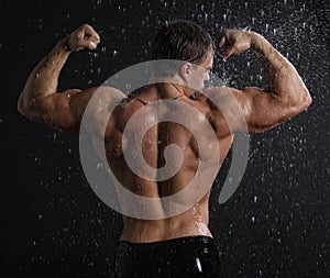 Wet muscle young man back under the rain