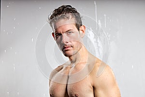 Wet muscular shirtless man isolated on gray studio background, portrait