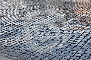 Wet old european city cobblestone pavement after the rain.