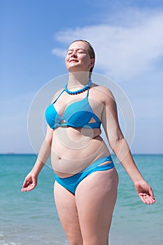 Wet overweight middle aged woman in blue bikini