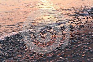 Wet pebble stones and water at morning seaside