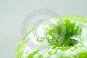 Wet Ripe Green Organic Apple with Water Drops on Light Grey Background. Macro Visible Texture. Creative Minimalist Image Banner