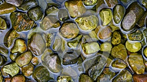 Wet river stones partially covered by water
