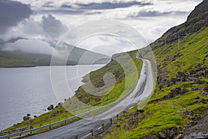 Wet road bordering a lake in the Faroe Islands photo