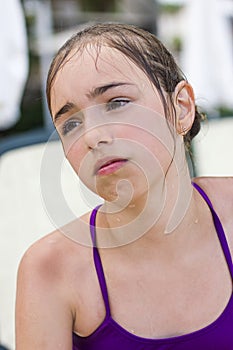 Wet sad girl in a swimsuit is crying in the pool