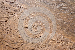 Wet sand texture. Beige sand macro. Dune background close up. Terrain pattern.