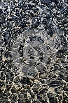 Wet sand and water strange, dark, abstract patterns