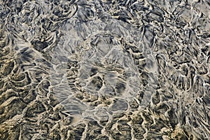 Wet sand and water strange, dark, abstract patterns