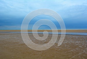 Wet sandy beach and deep blue sky, Northern Sea, Holkham beach, United Kingdom