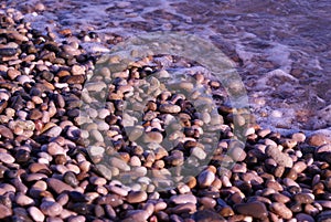 Wet sea pebbles on the sea beach