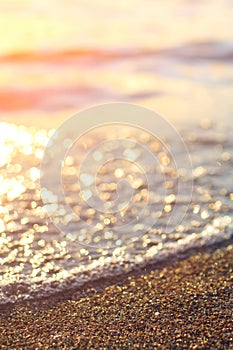 Wet sea sand on beach against background beautiful golden sunset. Close up sea sand on shore ocean during sunset.Landscape sunset