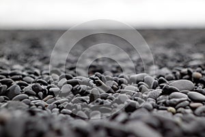 Wet small black stones on a beach