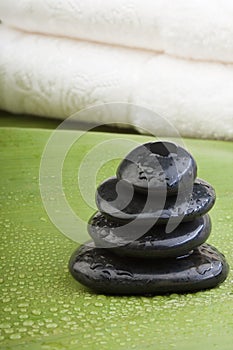 Wet spa hotstones on green leaf