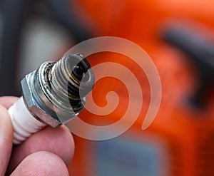 Wet spark plug in a chainsaw. Rich fuel mixture. Malfunction in the ignition system. industry