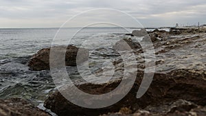 Wet stony coast washed by rippling sea