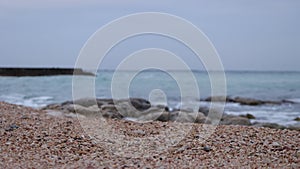 Wet stony coast washed by rippling sea