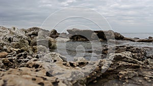 Wet stony coast washed by rippling sea