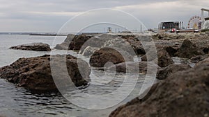 Wet stony coast washed by rippling sea