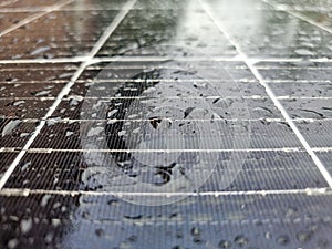 Wet surface of a photovoltaic solar panel with visible rain drops