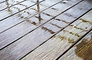 Wet surface of a terrace with wooden planks and splashing rain, Belgium