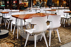 Wet tables and chairs in a modern summer cafe after the rain. Raindrops on the table. Veranda of the restaurant terrace