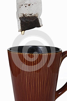 Wet tea bag above ceramic mug