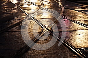 Wet trolley railes in the light and streets