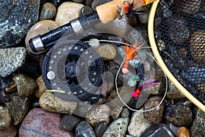 Wet Trout fishing gear on river rocks