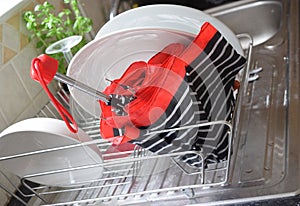 Wet umbrella is drying in a dish rack.