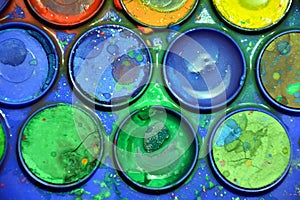 Wet used colorful palette, artist`s bright colorful palette, close up