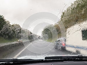 Wet windscreen from rain overtaking car towing a caravan.