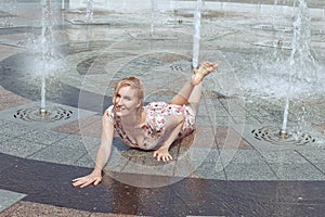 Wet woman lies in a fountain.