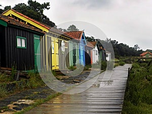 Wet wooden path after the rain, lonely wooden huts. Ocean, Ile d\'Oleron, France