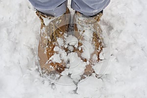 Wet yellow boot in the cold water and snow