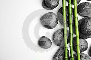 Wet zen stones and bamboo on white background, top view