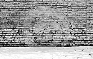 Wethered brick wall and pile of snow.