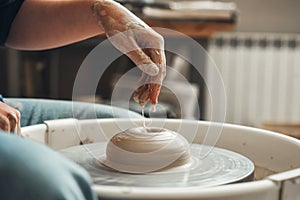 Wetting a clay product with water on a potter& x27;s wheel