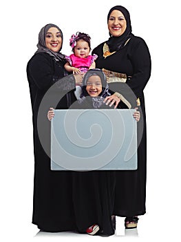 Weve got a lot to say. Studio portrait of the female members of a muslim family holding up a blank sign isolated on