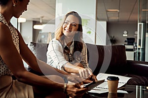 Weve got the perfect app to make our job easier. two young businesswomen using a digital tablet while going over some