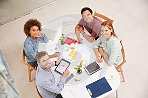 Weve got this project covered. High angle portrait of a group of businesspeople working together around a table in an