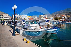 Wharf with citylights and cosy traditional Greek boats in small