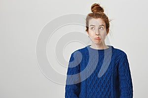 What a bummer. Portrait of frustrated attractive redhead caucasian female student in winter sweater sulking and looking