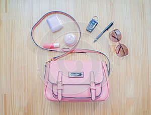 What comes from an open bag? Cosmetics, silver and accessories of women fall out of pink handbags.