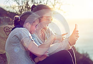 What is that. Cropped shot of two teenage girls reading an sms outdoors.