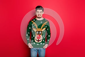 What a disgust. Portrait of frustrated man look at his funny ugly sweater dislike his christmas present wear denim jeans